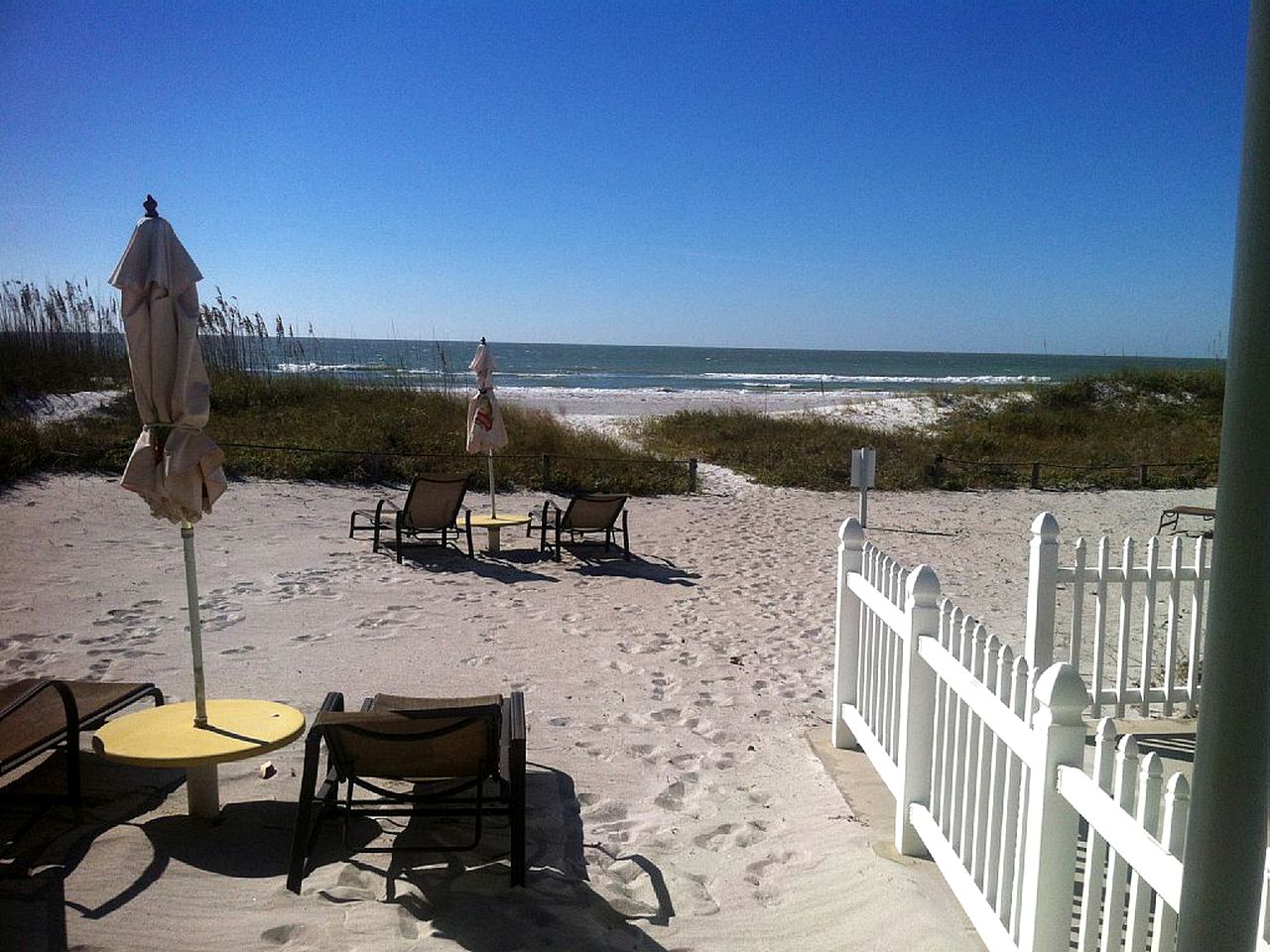 View from vacation rental on beach in Florida overlooking sand dunes and the water.