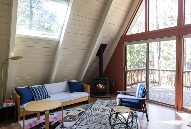 Living area with fireplace and sofa of private cabin rental for families.