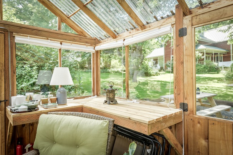 Living room with large windows looking out over the surrounding field of the cottage rental.