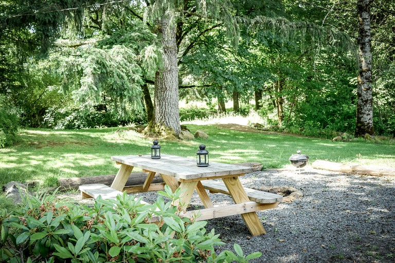 Backyard of cottage rental with wooden picnic table