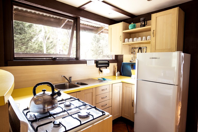 Kitchen with small stove and refrigerator in Capertee cabin rental in NSW.