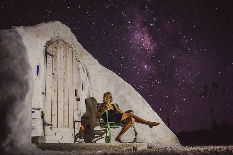 woman sat outside Texas adobe dome perfect for glamping, TX